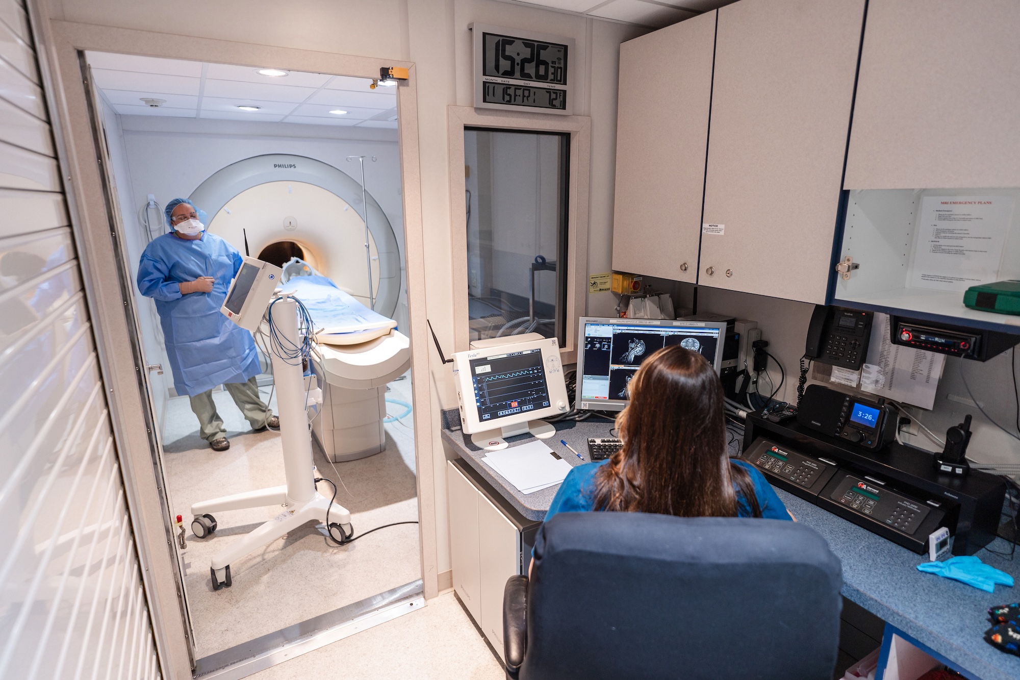 Two technicians operating an MRI machine.
